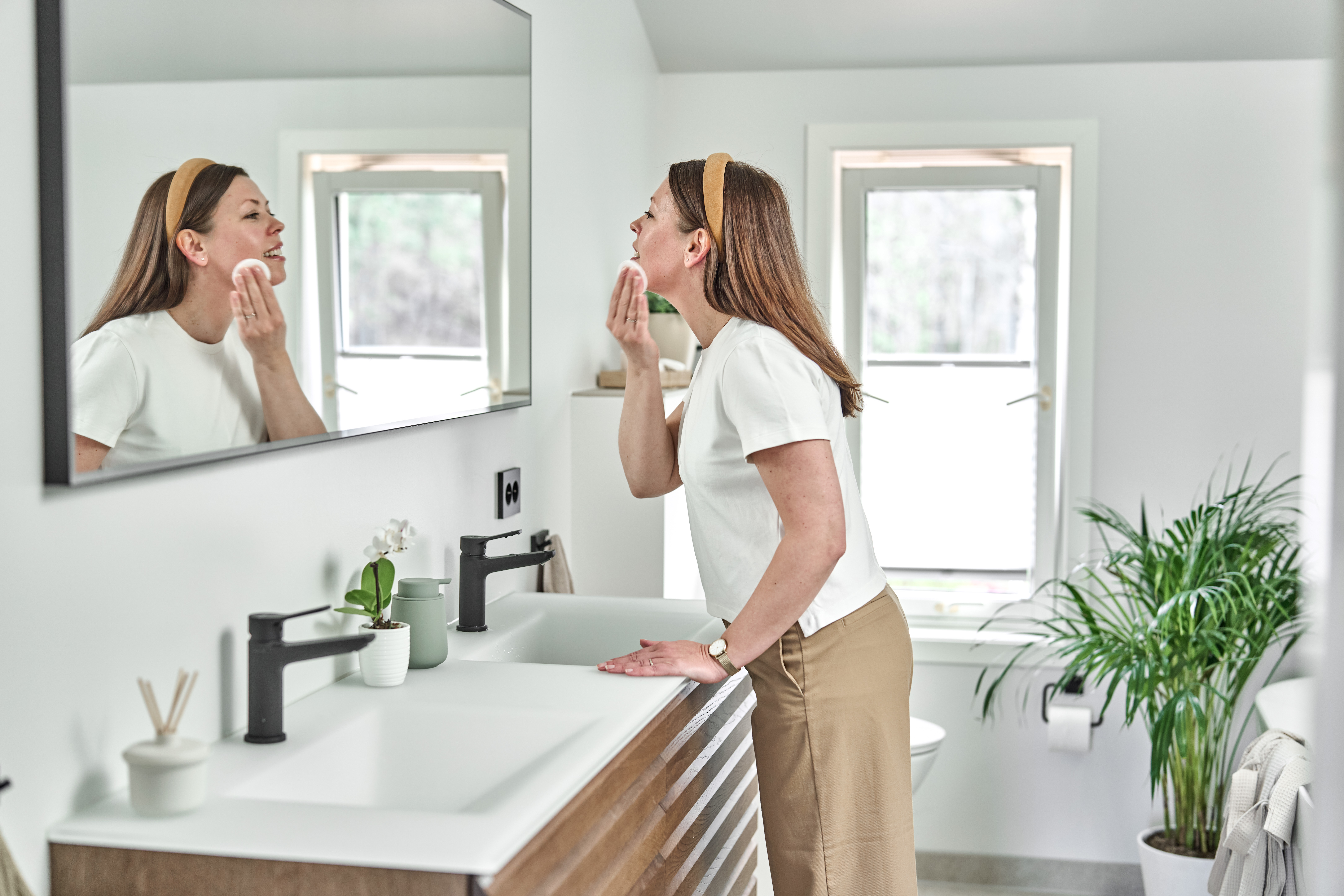 Kvinne foran speilet på badet
